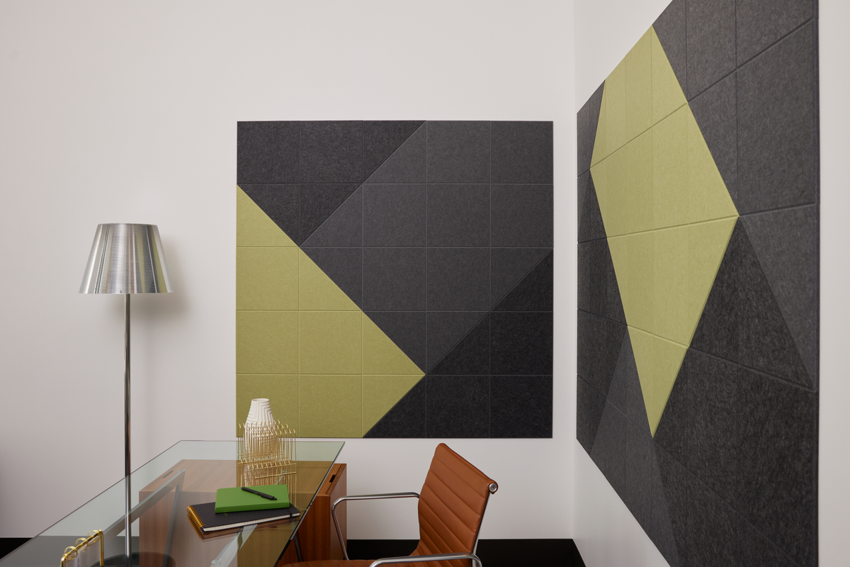 Felt Right wall art design in shades of  black, grey, and green creating a geometric pattern on two walls of an office by the desk