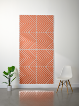 Thick felt sheet with orange and cream layered geometric chevron and diagonal stripe pattern arranged in four quadrants.