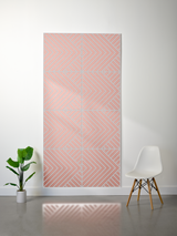 Layered felt sheet with engraved geometric chevron pattern in coral and gray tones, hung on white wall.