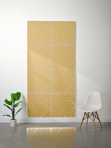 Yellow and white layered felt sheet with engraved geometric chevron pattern displayed on wall.