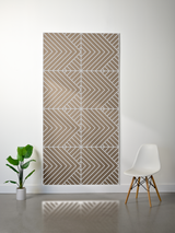 Taupe felt sheet with engraved geometric chevron pattern arranged in four quadrants, mounted on white wall.