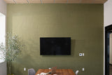 Olive-green textured wallpaper with linear pattern on office wall behind desk.
