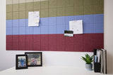 Modular wall panels in tan, blue, and burgundy arranged in horizontal color-blocked rows above a white desk.