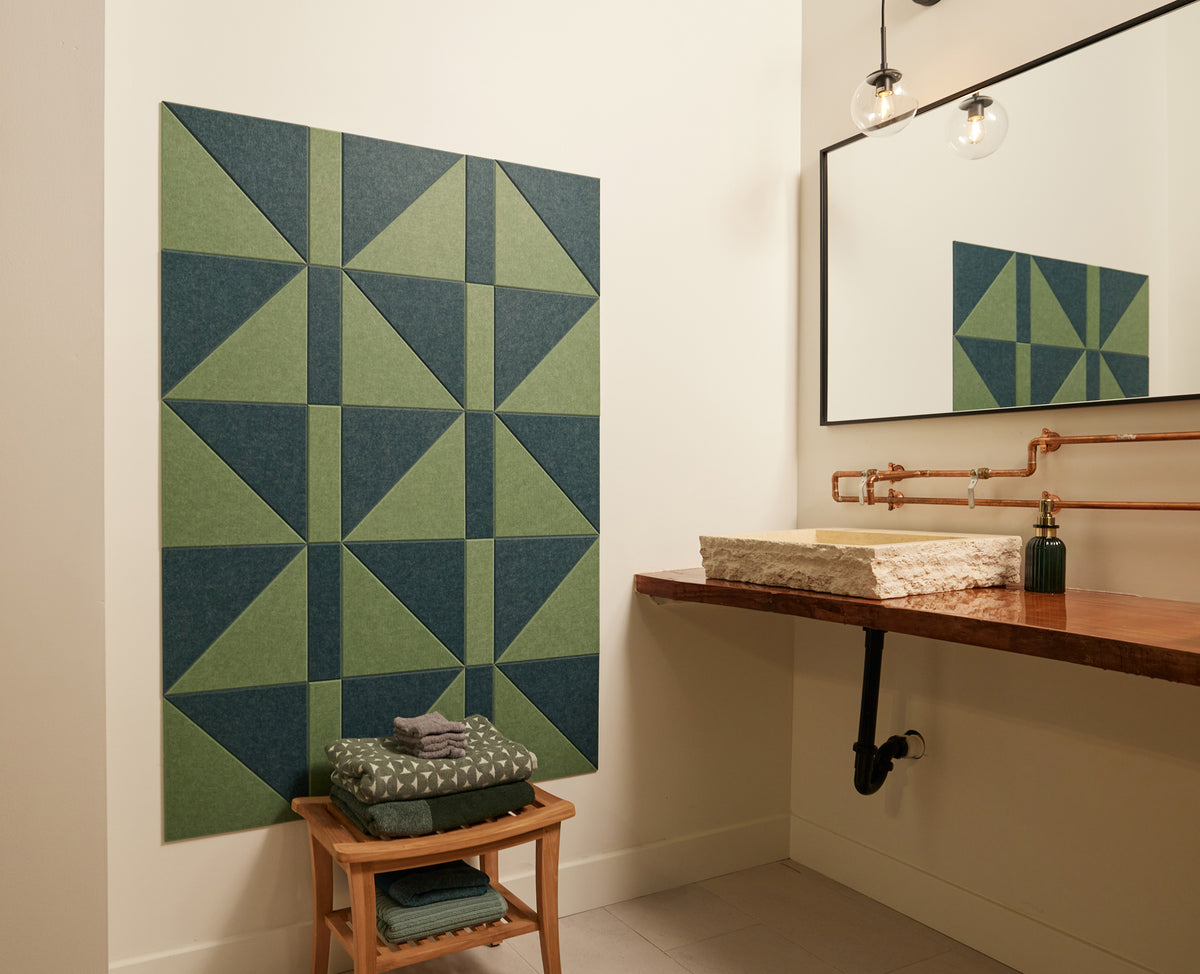 Felt Right wall art design in shades of green felt tiles in a geometric pattern on a wall in a bathroom next to a sink