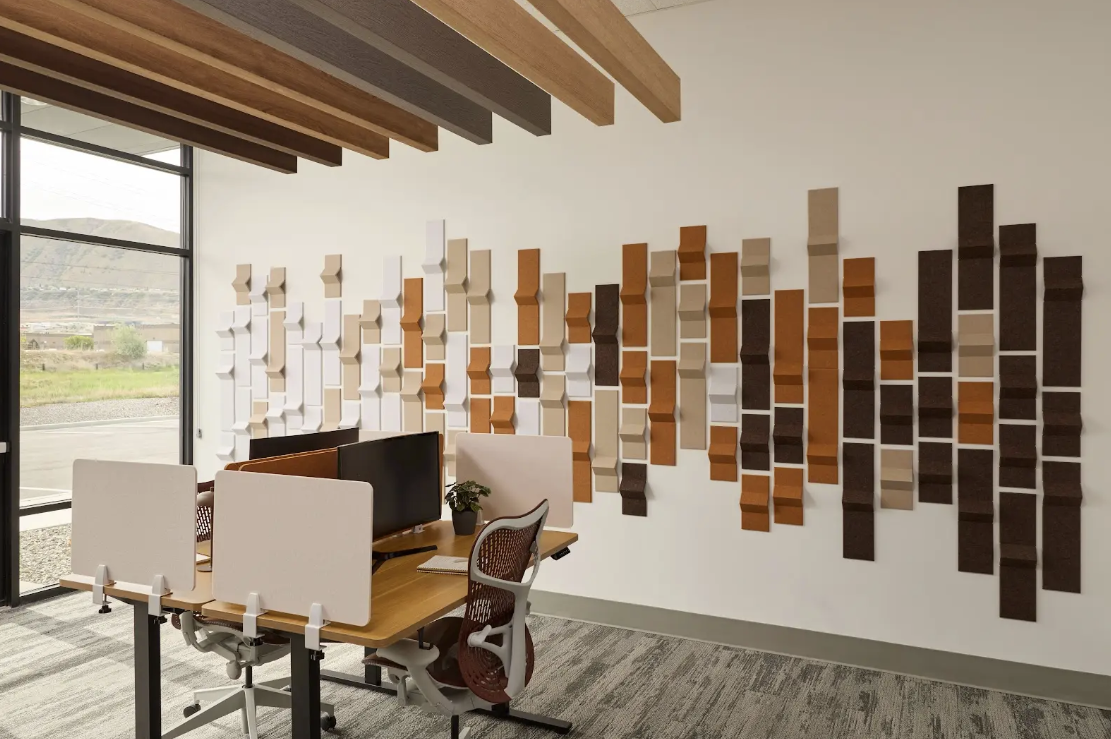 Modern office interior with a wall of geometric wooden panels.