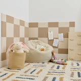 Cashmere and ivory checkerboard felt tiles in a boho playroom with a bean bag