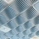 Powder Blue Ripple felt drop ceiling tiles in a ceiling grid with a smoke detector