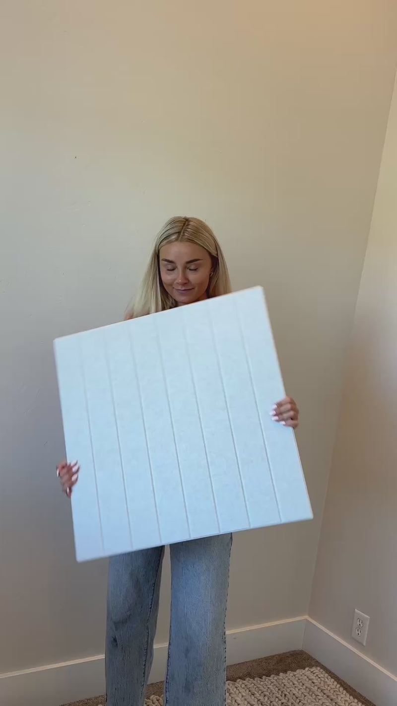 Woman installing peel and stick scalloped wainscoting in playroom