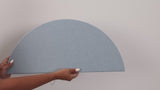 Woman holding peel and stick scallop tile and putting it on the wall