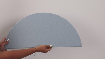 Woman holding peel and stick scallop tile and putting it on the wall