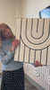 Women installing layered engraved acoustic panel in a conference room.