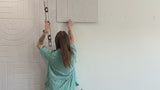 Woman installing peel and stick acoustic panels and b roll of more accent walls.