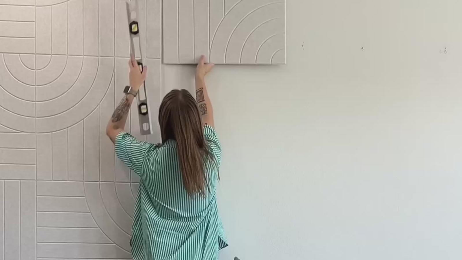 Woman installing peel and stick acoustic panels and b roll of more accent walls.