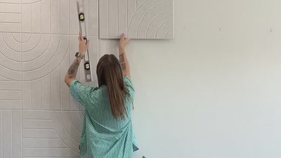 Woman installing peel and stick acoustic panels and b roll of more accent walls.