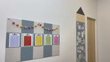 Classroom with multiple colors of checkerboard and pencil bulletin boards with papers pinned to them