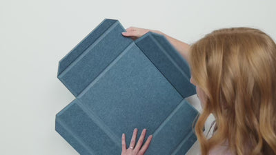 woman installing 3d felt acoustic boxes with tape, glue, and screws optionns.