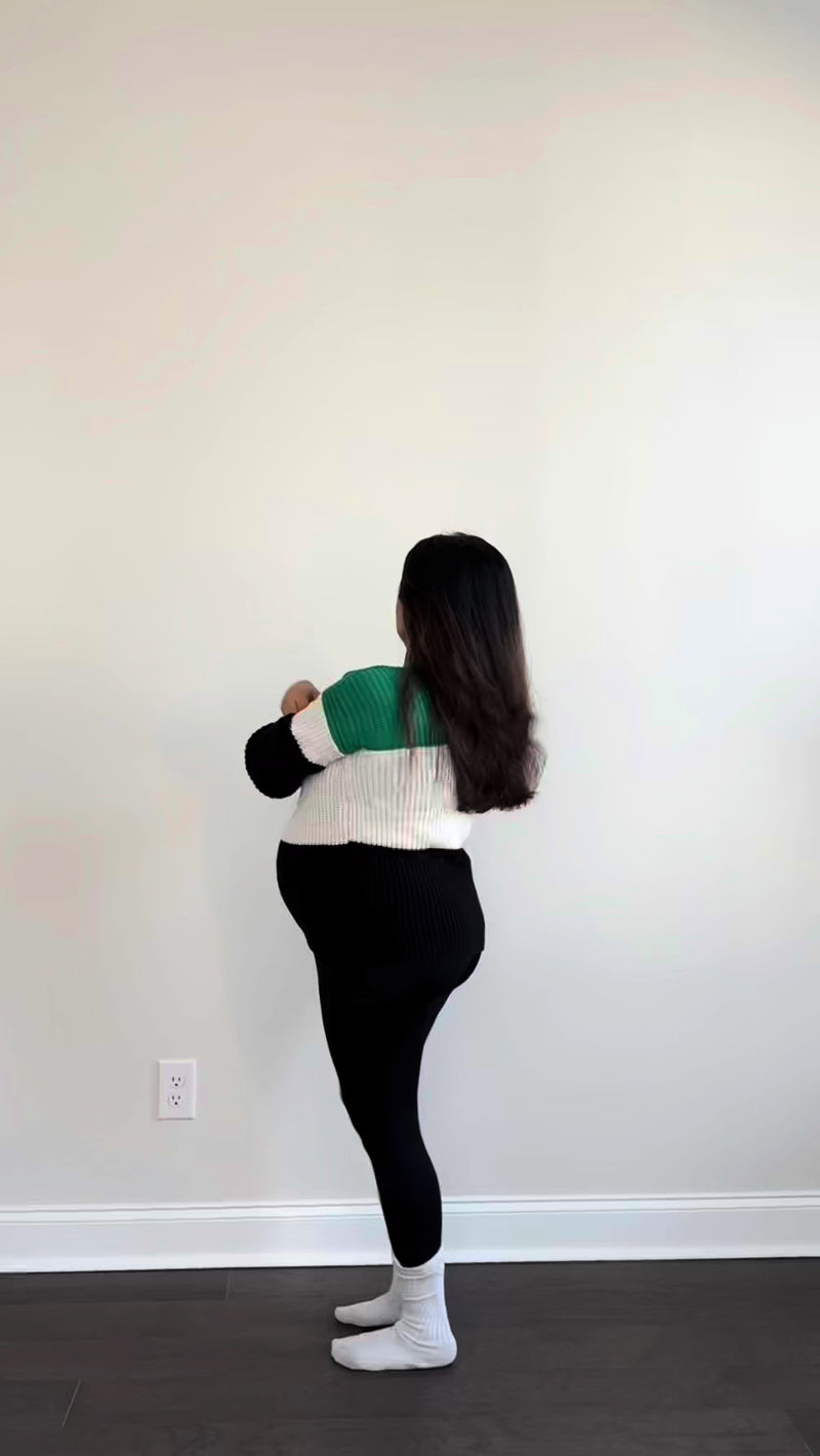 Woman installing green hexagon acoustic tiles on blank white wall