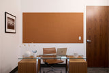 Cinnamon-toned wood wall panels with linear grain pattern installed above office desk.