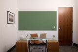 Green acoustic wall panel with leaf pattern texture mounted on white wall above desk.