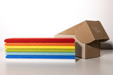 Stacked colorful cloths in red, orange, yellow, green, and blue next to an open kraft cardboard box.