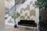 Felt Right wall art using cream and green diamond felt tiles to create a pattern on a wall with a bench and house plant in front