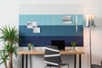 Felt Right Wall design that is pinnable and in ombre shades of blue in an office above a desk next to a lamp and a plant.