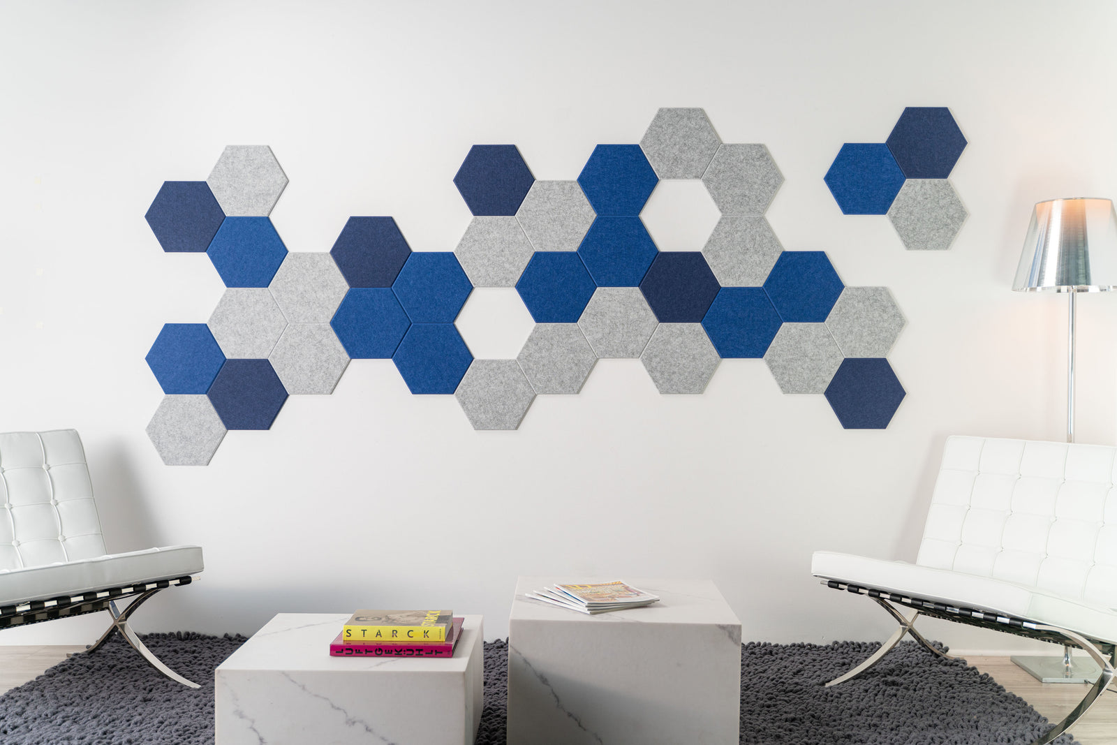 A Felt Right wall design on a wall adorned with a pattern of blue and gray hexagonal tiles in a living room setting.