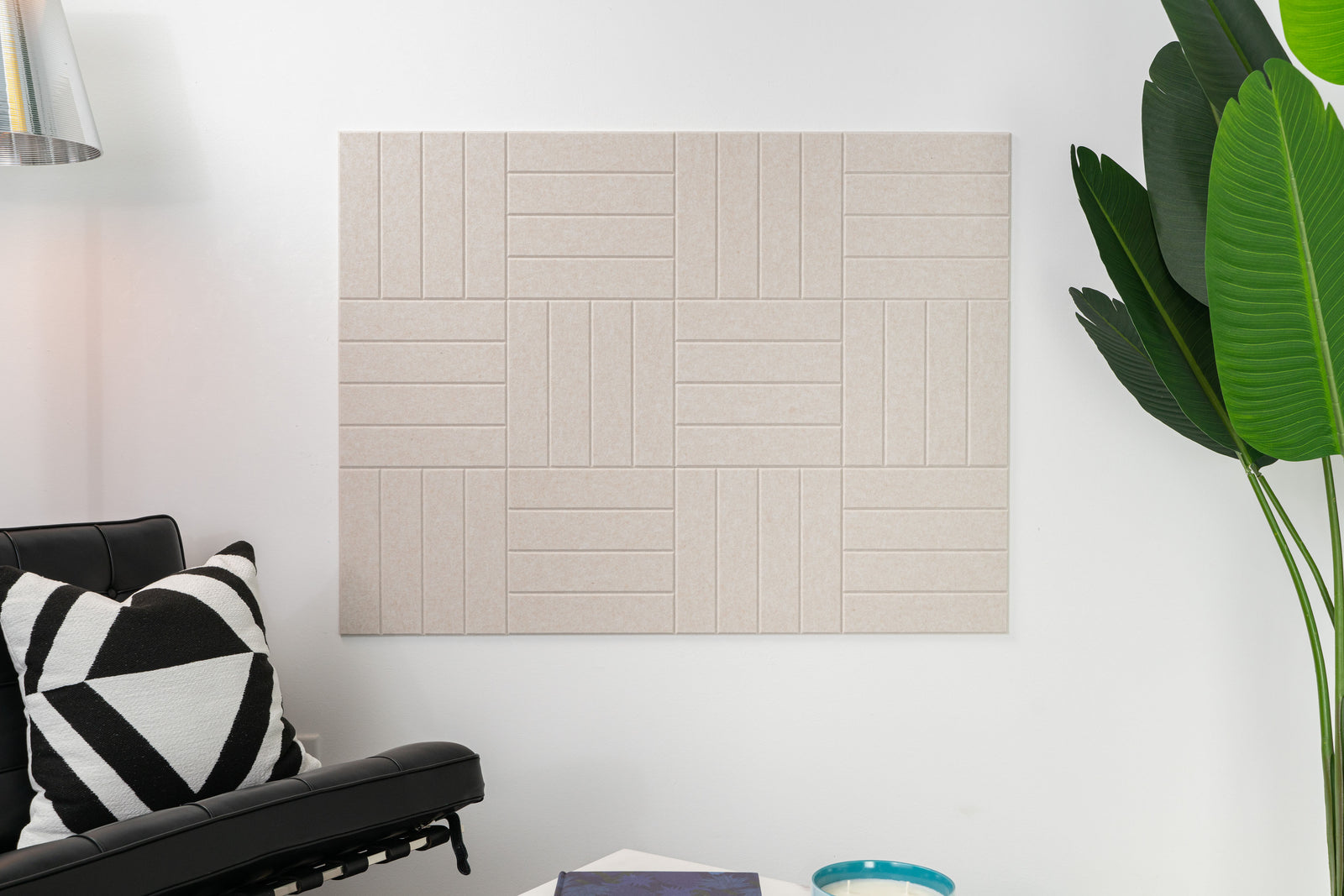 A Felt Right wall design acoustic panel in a living room setting, featuring a geometric pattern with beige and white tones.