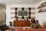 Felt Right wall art design in shades of brown, cream, and black on a wall with art mounted on it in a living room with women playing cards
