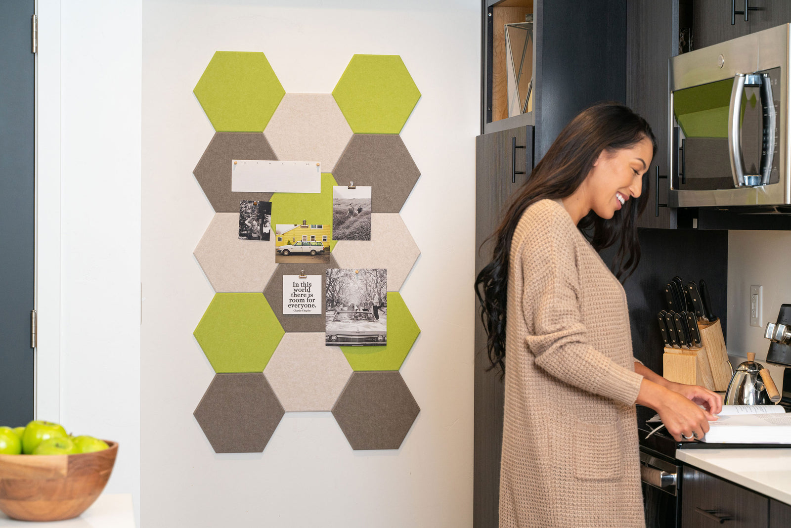 A pinnable Felt right wall art design in shades of green, cream, and grey hexagon felt tiles on a white wall in a kitchen.
