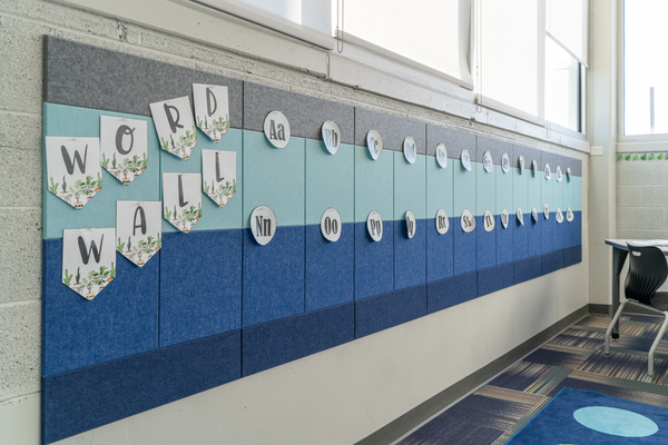 Blue and grey Felt Right acoustic panels on a cinder block wall in a classroom