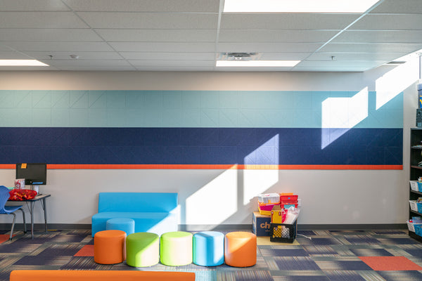 Baby blue, dark blue, and orange Felt Right wall panels in a classroom